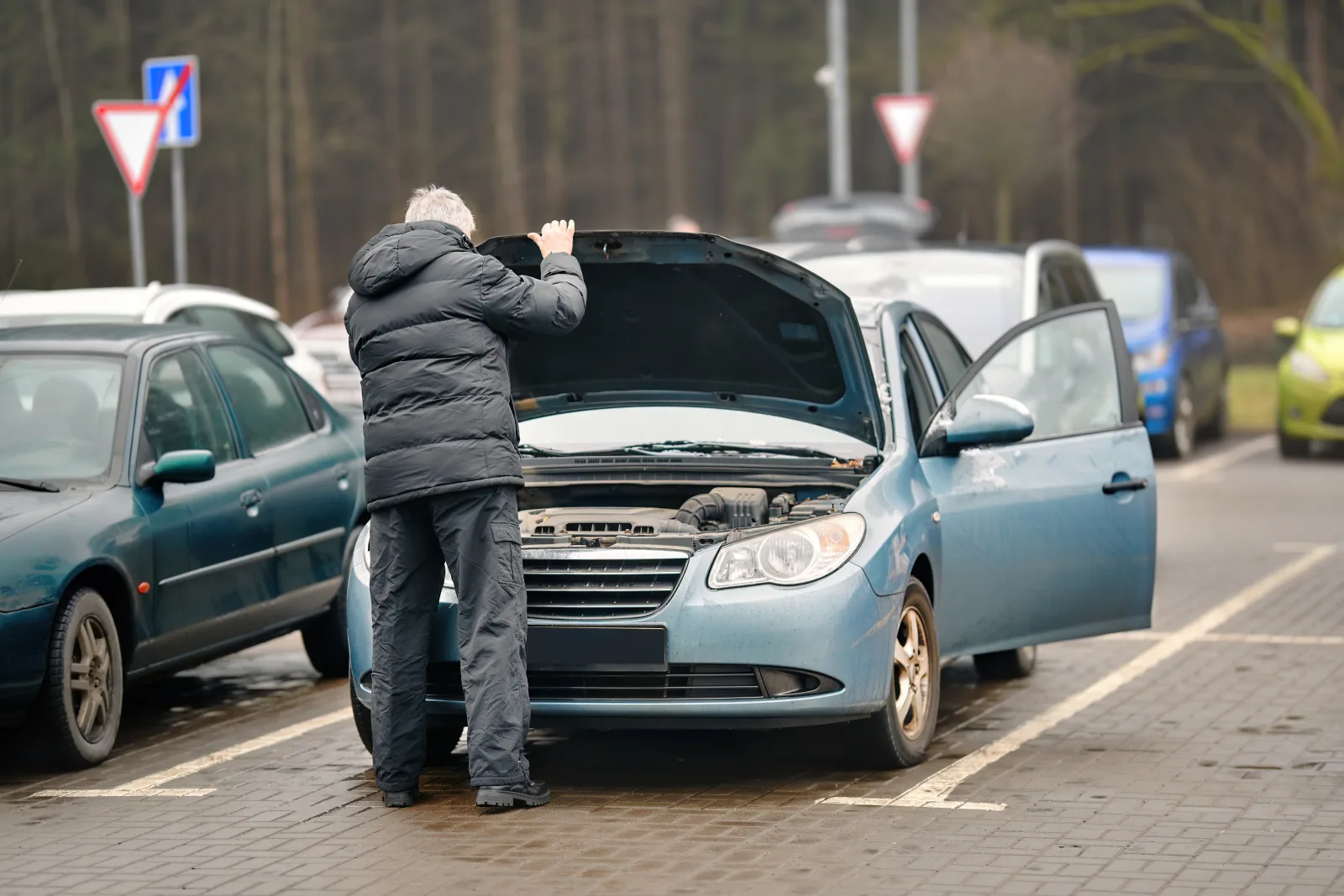 Driver checking a car that will not start even though the lights come on