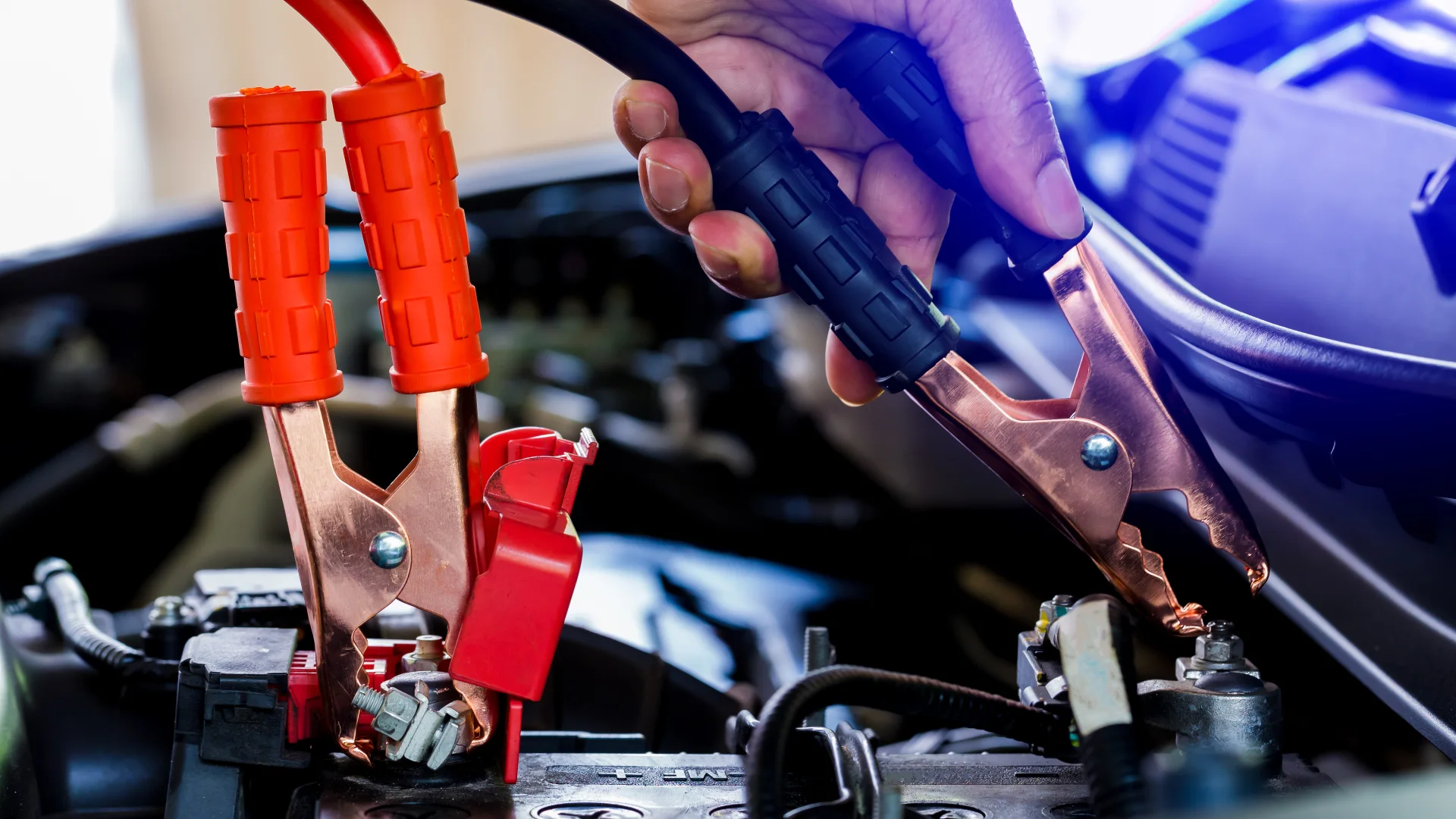 Technician providing jump start service for a vehicle